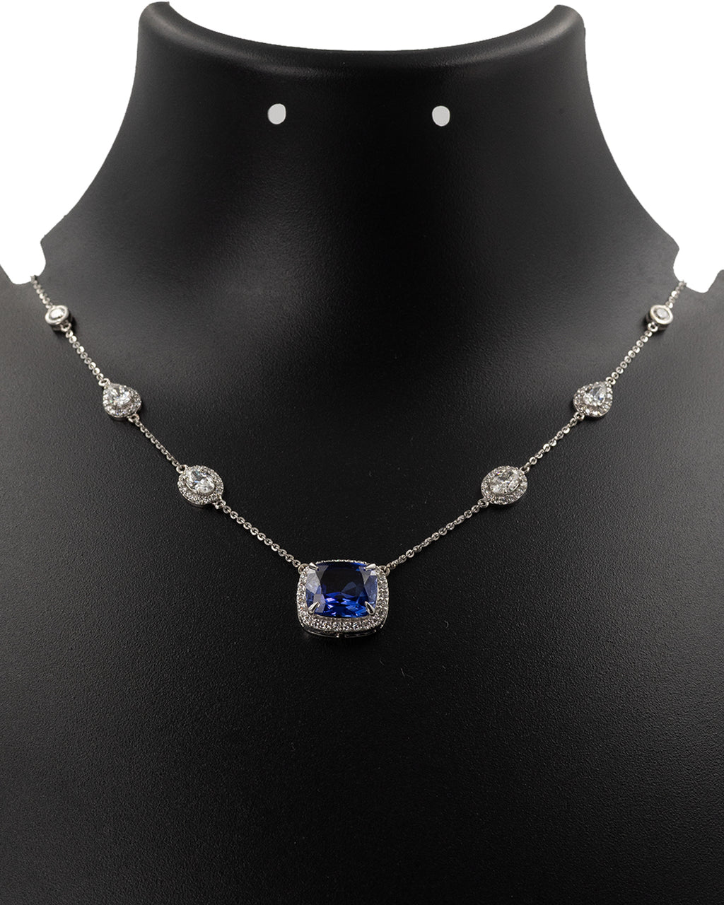 Blue sapphire and diamond station necklace in 14k yellow gold on display bust