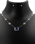 Blue sapphire and diamond station necklace in 14k yellow gold on display bust