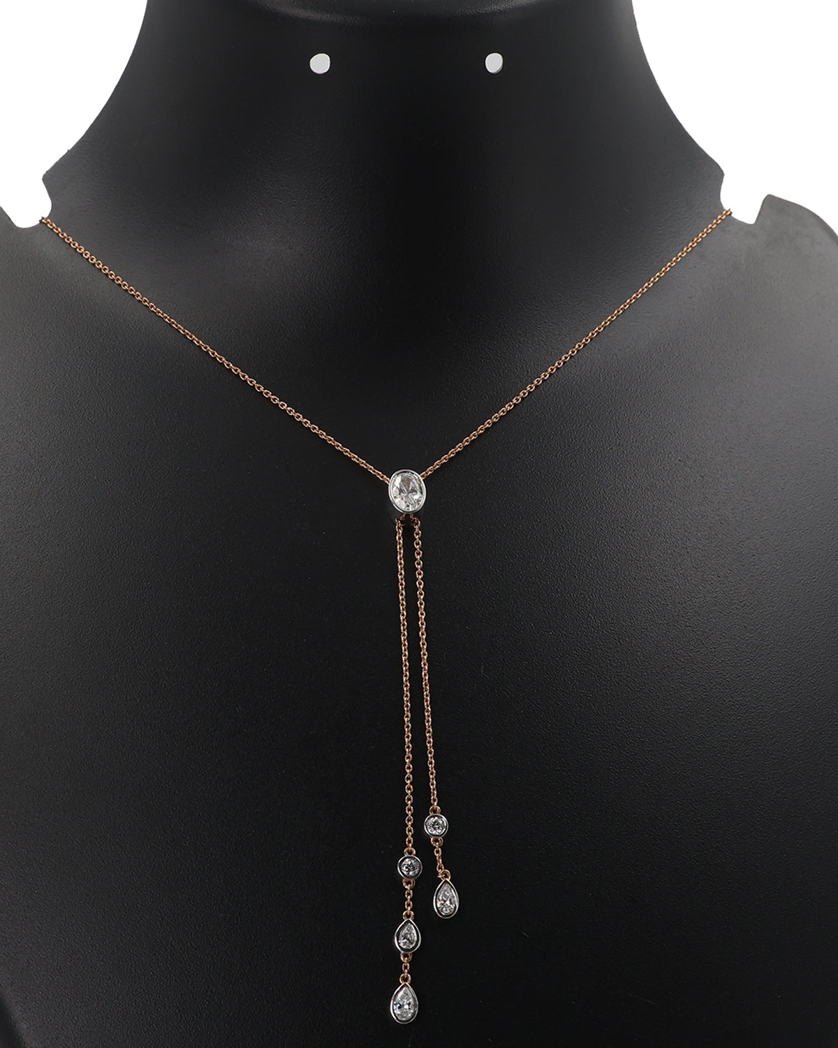 Necklace with a central diamond pendant and two smaller ones on a black mannequin.