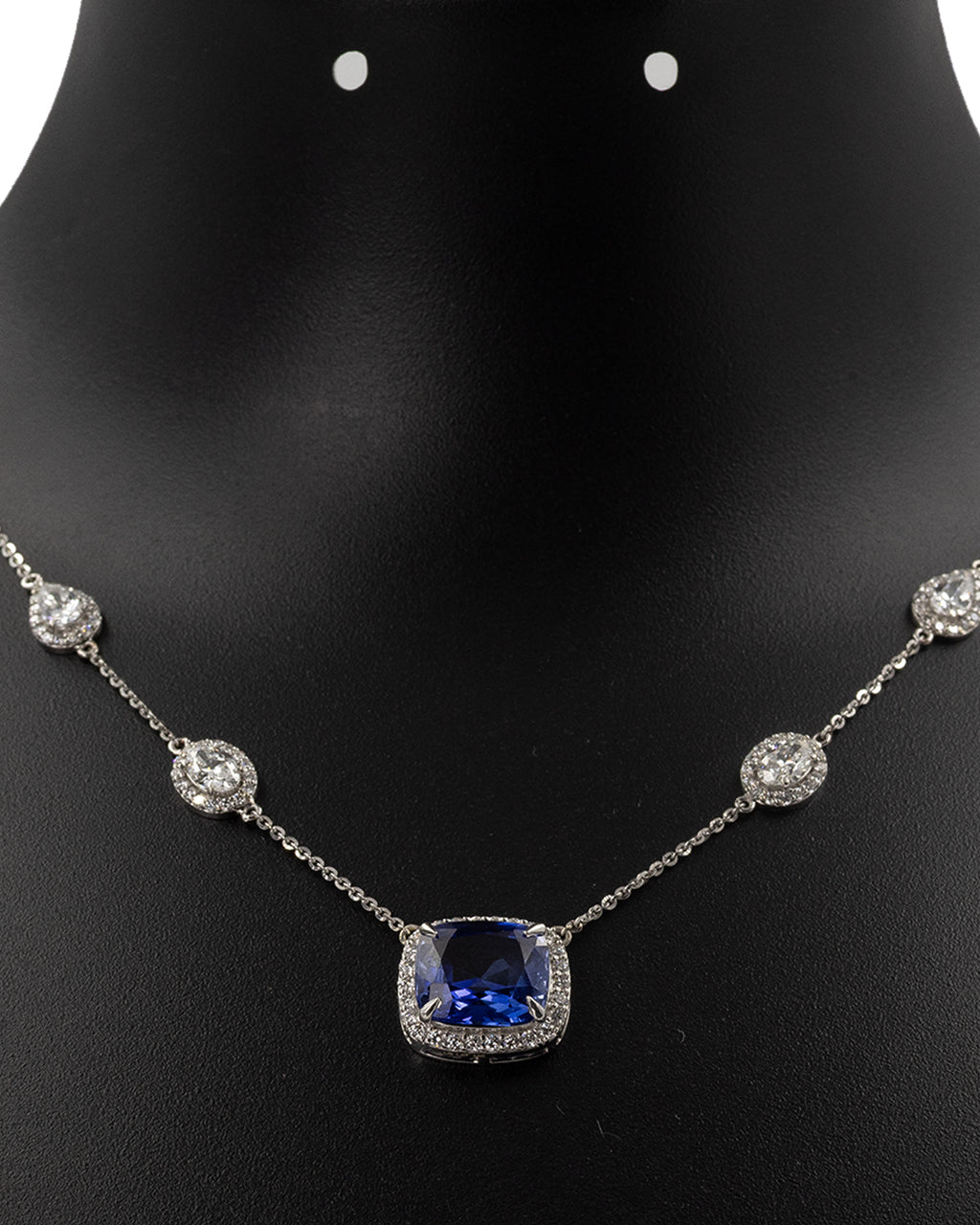 Blue sapphire and diamond station necklace worn on neckline
