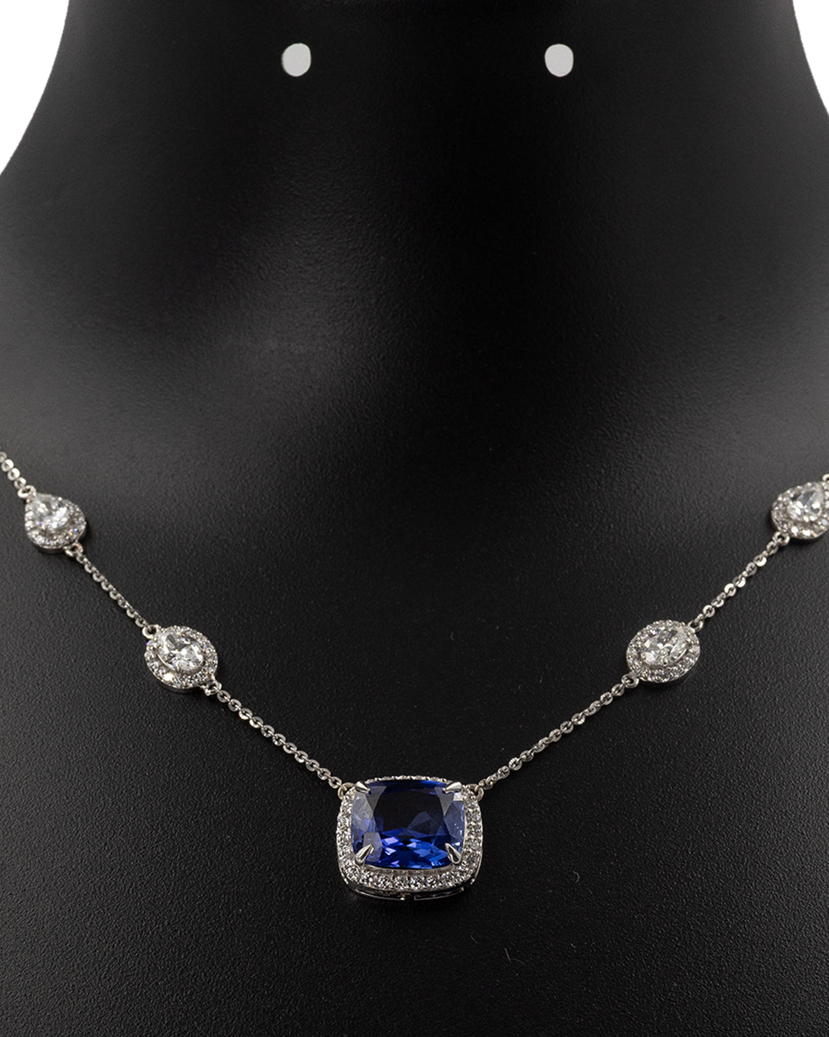 Blue sapphire and diamond station necklace worn on neckline