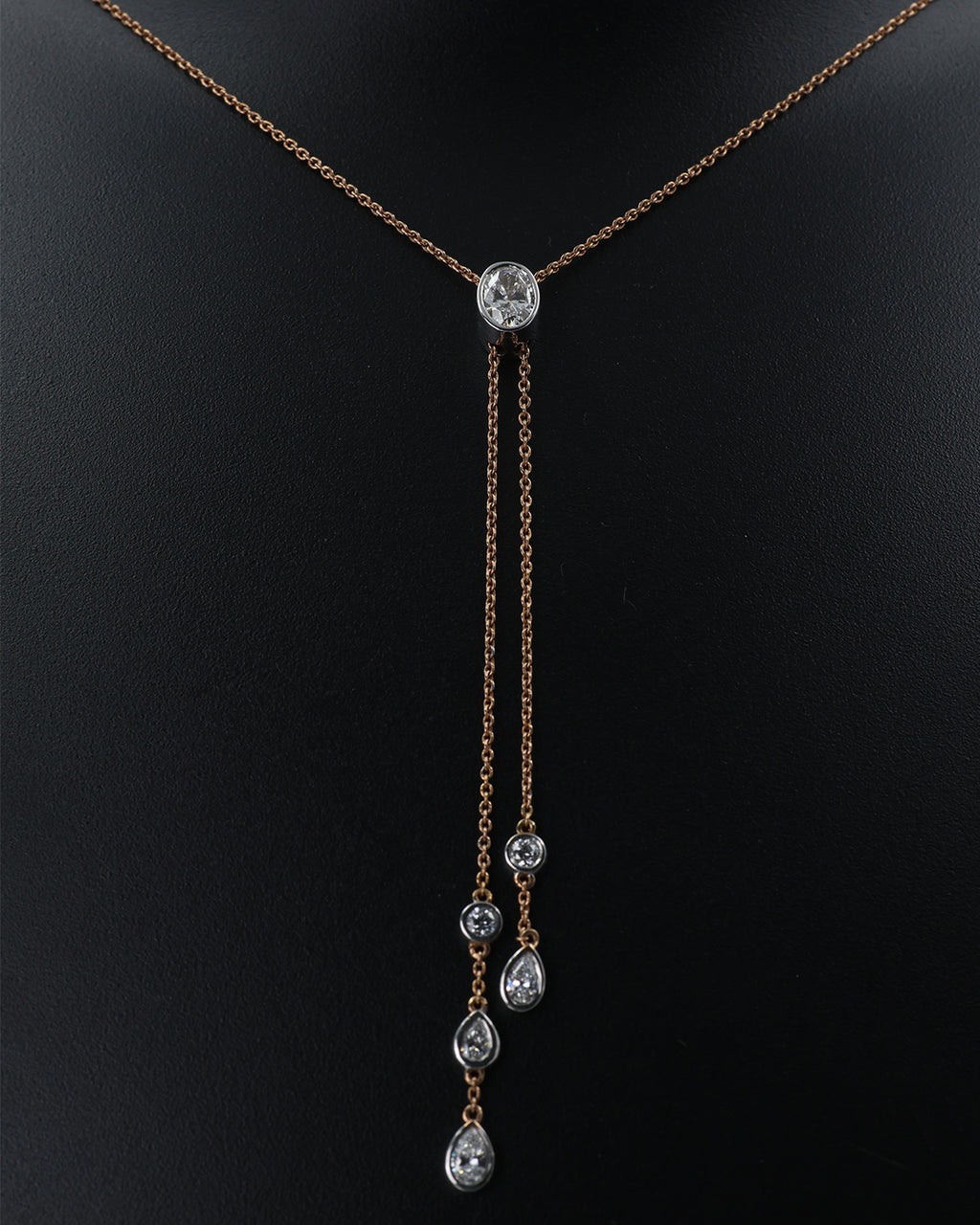 Delicate necklace with a central diamond and three smaller diamonds on a black background
