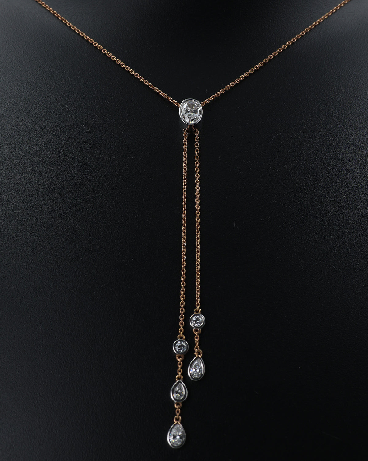 Delicate necklace with a central diamond and three smaller diamonds on a black background